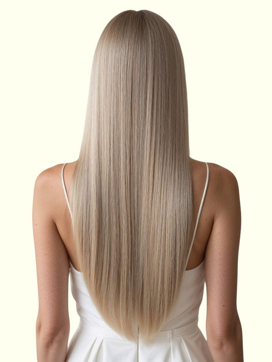 Woman with long, straight blonde hair wearing a white dress on a white background